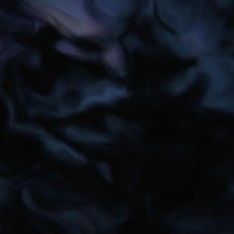 Dark iridescent ink flowing across a plate, caught mid-swirl in low light.